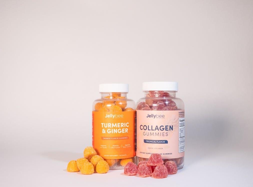 Jars of collagen and turmeric gummies with a few loose gummies on the table