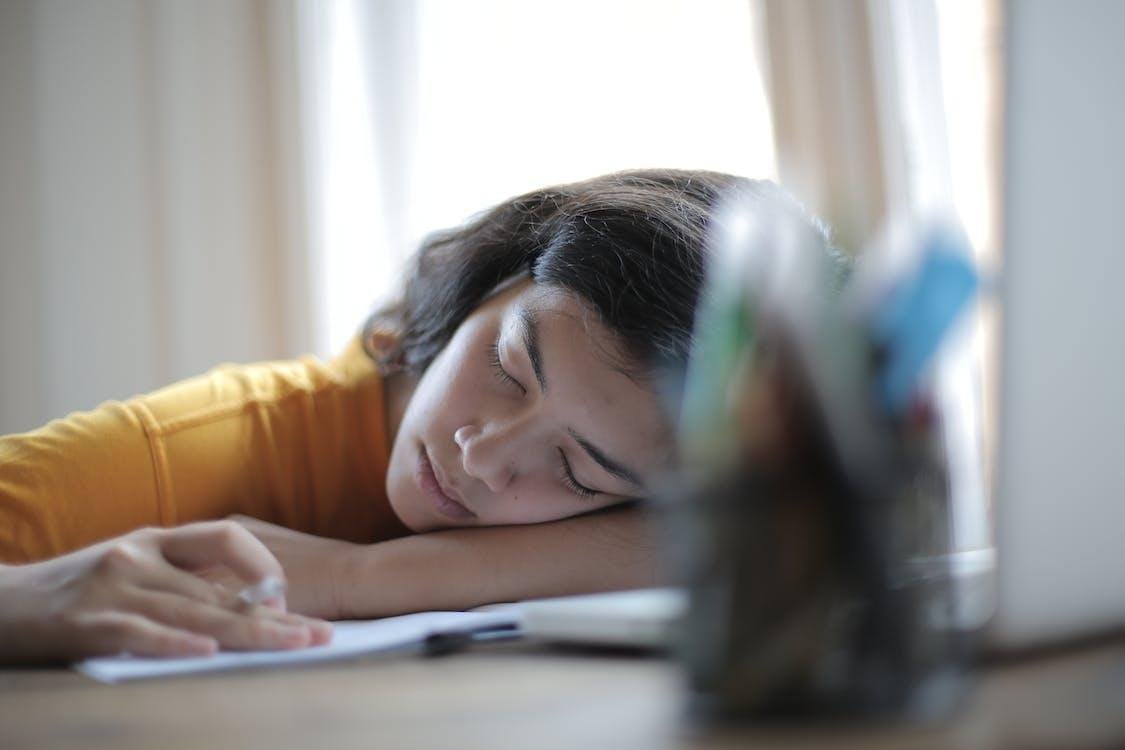Mujer dormida sobre su escritorio por cansancio