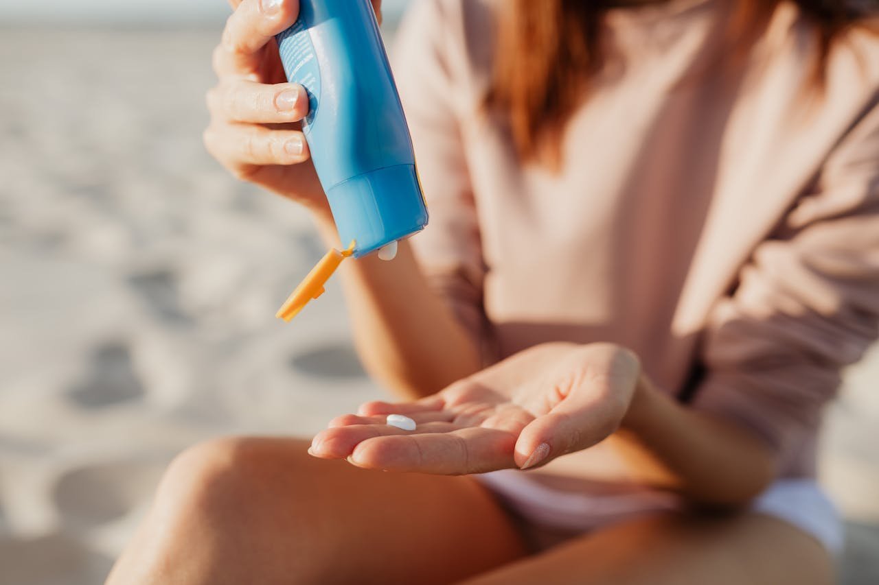 Mujer aplicándose protector solar con color en la mejilla con la yema de los dedos