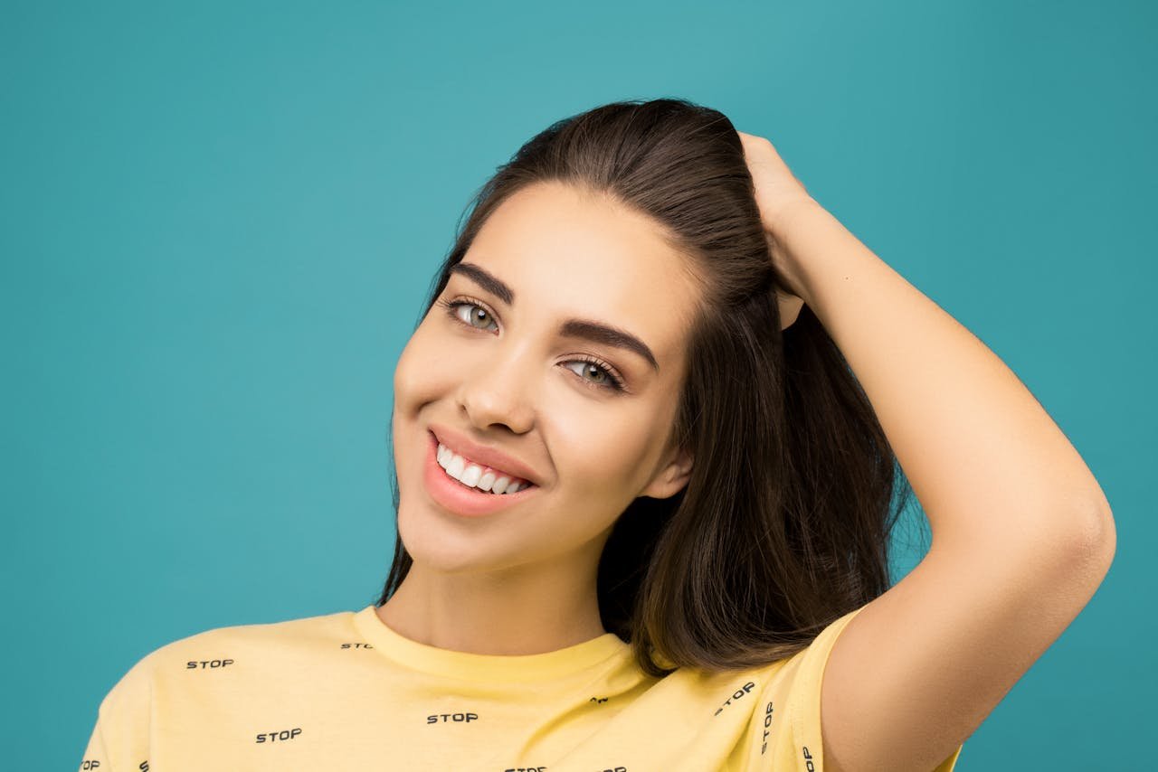 Smiling woman with naturally full lips, an example of the subtle upper-lip change a lip flip aims for