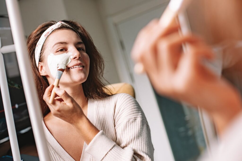 Persona aplicándose una mascarilla durante su rutina facial