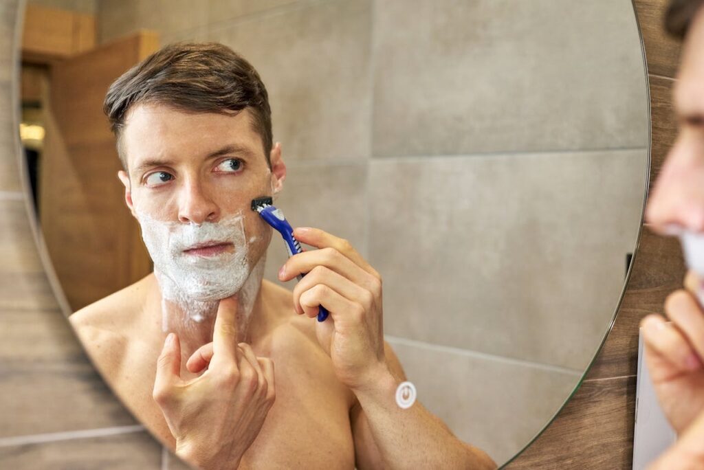 Hombre comienza su rutina de skincare frente al espejo