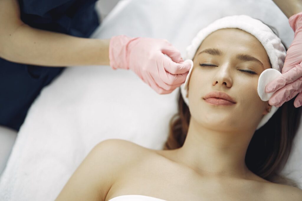 Mujer joven recibiendo un tratamiento facial en medicina estética