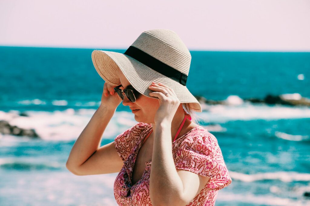 Mujer cuidando su piel en verano con un sombrero