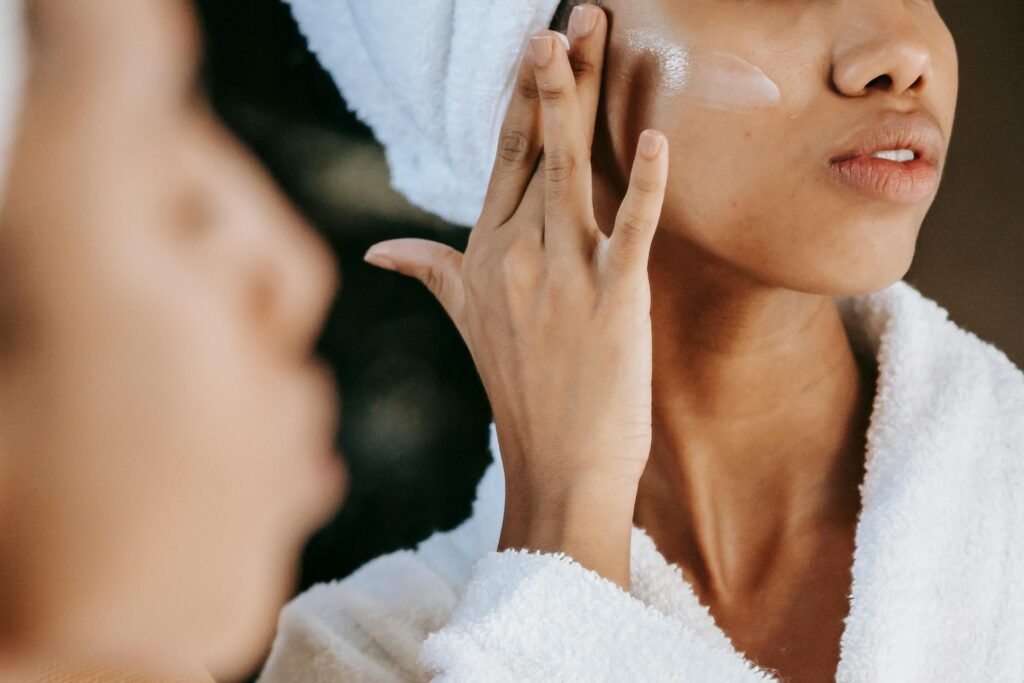 mujer morena utilizando una capa de protector solar facial