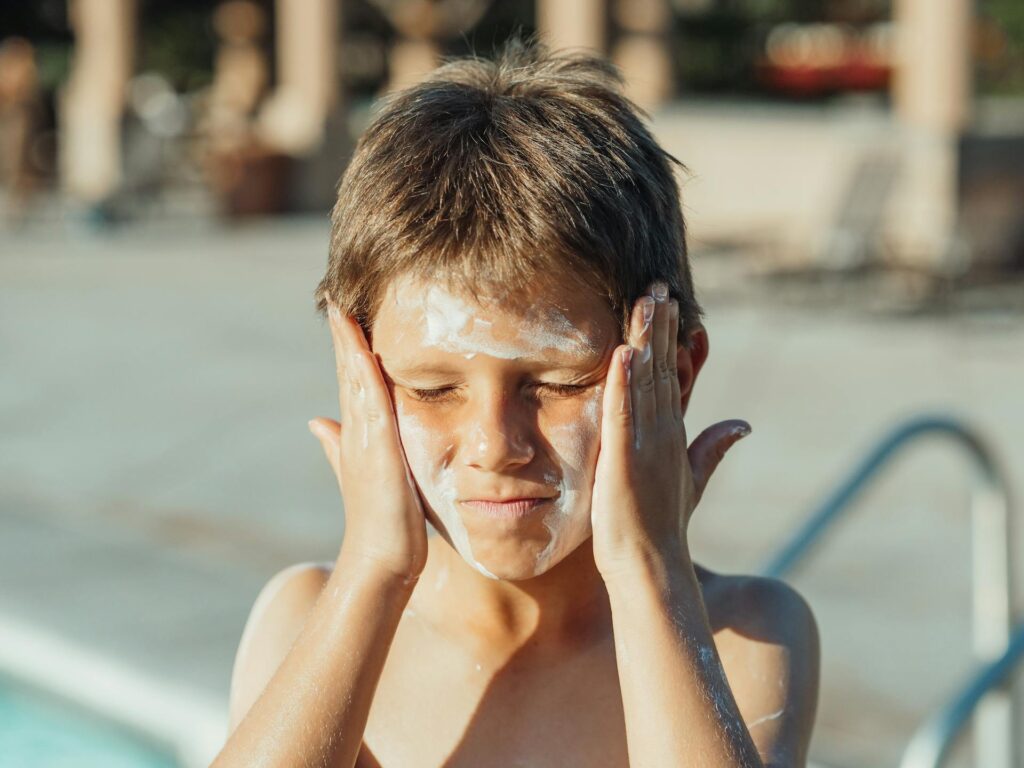 niño cubierto de protector solar para la cara